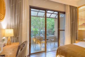 a bedroom with a bed and a balcony with a table at Heinemann Hotel courtyard or terrace king room A108 with a jacuzzi and a local in Baoguosi