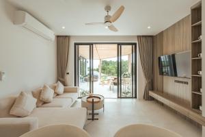 a living room with a couch and a tv at Staylar Sunrise Villas - Chaweng Noi, Koh Samui in Amphoe Koh Samui