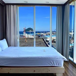 a bedroom with a bed and a view of the ocean at Seom Guesthouse in Seogwipo
