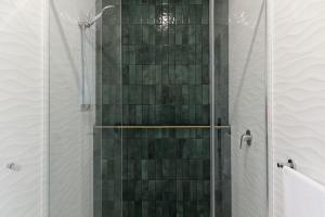 ein Bad mit einer Dusche und grünen Fliesen in der Unterkunft Tuckeroo Cottages - Cockatoo Cottage in Bigriggan + 25 Fotos