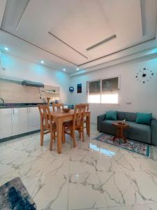 ein Wohnzimmer mit Tisch und Couch in der Unterkunft Perla House in Imsouane