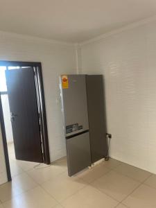 una nevera en la esquina de una habitación con puerta en The Spaggy family villa, en Accra