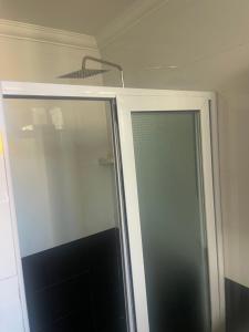 una ducha con puerta de cristal en un baño en The Spaggy family villa, en Accra