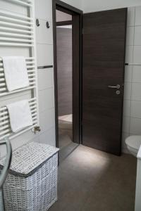 a bathroom with a wooden door and a sink at F&M Apartman in Egerszalók +19 photos
