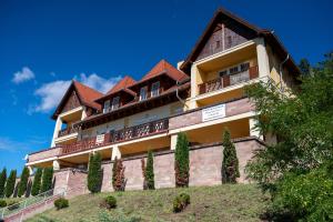 a building on top of a hill with trees at F&M Apartman in Egerszalók