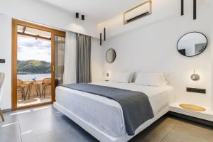 a bedroom with a large bed and a balcony at Blue Green Bay in Panormos Skopelos