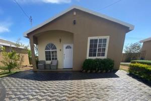 a small house with a white door at 2-Bed Sleeps 4 Private Garden Parking in Portmore