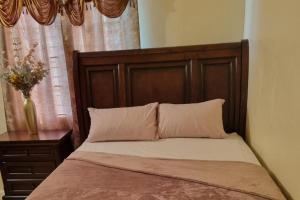 a bed with a wooden headboard and a vase of flowers at 2-Bed Sleeps 4 Private Garden Parking in Portmore