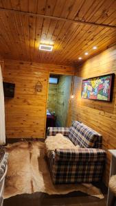 a couch sitting in the middle of a room with wooden walls at Casa Container Branca in Bagé
