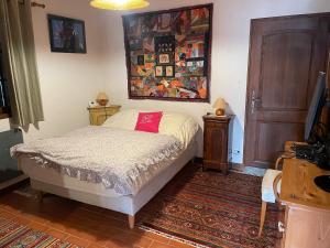 a bedroom with a bed and a painting on the wall at Séjour dans ferme de 1876 in Marignier