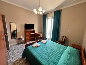 a bedroom with a green bed with two towels on it at VIMAVÌ Rooms & Apartment in Catania