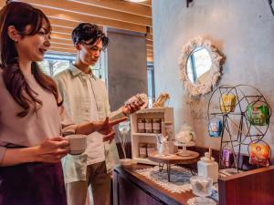 札幌市にあるホテルリリーフ札幌すすきののキッチンでコーヒーを飲んでいる男性と女性