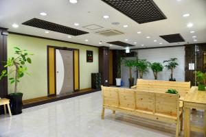 a lobby with benches and plants in a building at Seom Guesthouse in Seogwipo