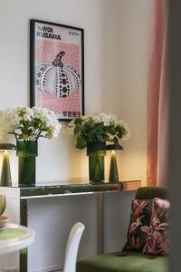 two vases with flowers on a shelf with a chair at Boutique Accommodation in London +183 photos