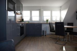 una cucina con armadi blu, tavolo e sedie di Deichstübchen oben a Norddeich