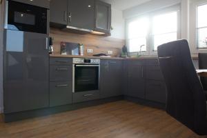 una cucina con elettrodomestici in acciaio inossidabile e pavimenti in legno di Deichstübchen oben a Norddeich