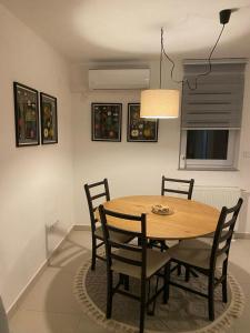 a dining room with a wooden table and chairs at Apartman Turić Vinkovci in Vinkovci +7 photos