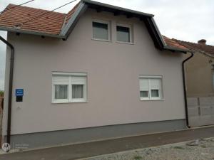 a white house with three windows at Apartman Turić Vinkovci in Vinkovci