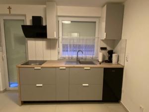 a small kitchen with a sink and a window at Apartman Turić Vinkovci in Vinkovci