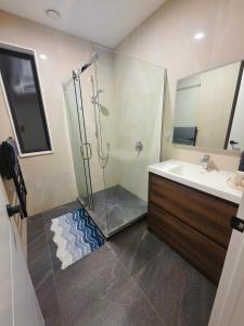 a bathroom with a shower and a sink at Long Bay Breeze Ensuite in Auckland