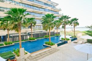an overhead view of a hotel with palm trees and a swimming pool at Beachside Sunset Residence in Abu Dhabi