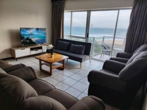 a living room with couches and a tv and the ocean at Santana Resort 401 in Margate