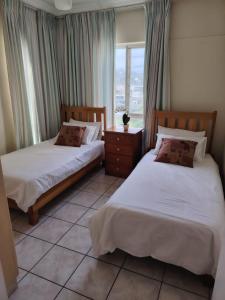 two beds in a room with a window at Santana Resort 401 in Margate +20 photos