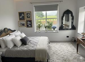 兰纳加Privé Residence的一间卧室配有一张带窗户和镜子的床