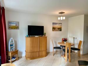 a living room with a television and a table at Seemöwe in Binz