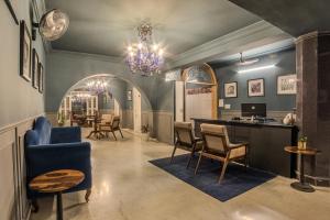 a living room with a chandelier and a desk and chairs at Victoria Mansion - A Signature Collection by HST Hotels, Pure Vegetarian in Udaipur