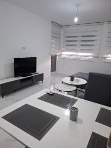 a living room with a tv and a couch and a table at Apartman Ditka in Bihać