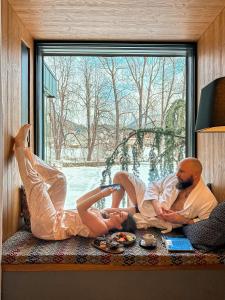 a man and a woman laying on a window sill at Boutique Hotel Sunrose 7 - Gourmet & SPA in Bohinj
