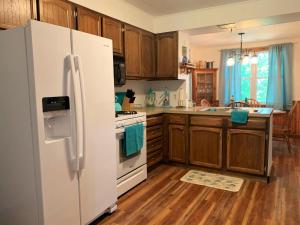 a kitchen with a white refrigerator and wooden cabinets at The Blue Bliss in Saint Ignace +16 photos