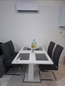 a white table with black chairs in a room at Apartman Ditka in Bihać +9 photos