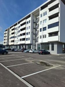 a parking lot with cars parked in front of a building at Apartman Ditka in Bihać