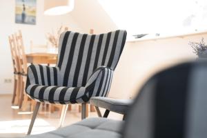 a black and white striped chair and a table at Bargmöhl 7 Heber in Wulfen auf Fehmarn