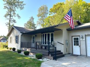 a house with an american flag on the front of it at North Country Retreat in Saint Ignace