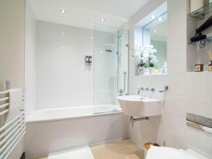 a white bathroom with a shower and a sink at Stylish 2BR City-Centre Apart Near LGI & Leeds Uni Sleeps 6 in Leeds