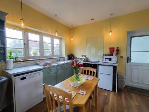 a kitchen with a table with a vase of flowers on it at 1 Bed in Whissonsett 77597 in Whissonsett