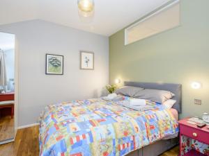 a bedroom with a bed with a colorful quilt at 1 Bed in Whissonsett 77597 in Whissonsett