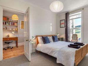 ein Schlafzimmer mit Bett, Schreibtisch und Fenster in der Unterkunft 4 Bed in Woolacombe 90224 in Mortehoe