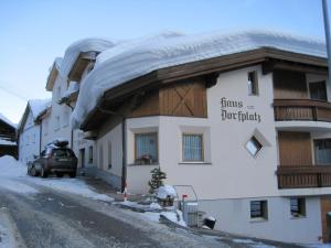 ein Gebäude mit Schnee drauf in der Unterkunft Haus am Dorfplatz in Samnaun