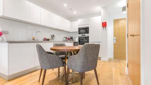a kitchen with a wooden table and chairs at Apartment 105 in Birmingham +18 photos