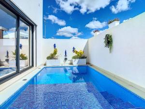 a swimming pool in a house with a window at Casa Launa Fuseta in Fuzeta