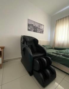 a bedroom with a black chair and a bed at Homestay,Gaming in Shah Alam