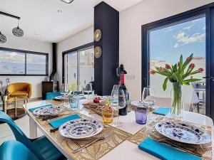a dining room table with plates and glasses on it at Casa Launa Fuseta in Fuzeta