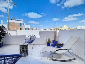 a balcony with a chair and a view of a city at Casa Launa Fuseta in Fuzeta
