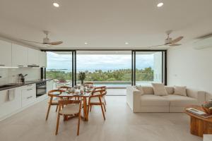 a kitchen and living room with a table and chairs at Staylar Sunrise Villas - Chaweng Noi, Koh Samui in Amphoe Koh Samui