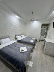 a bedroom with two beds and a chandelier at Old Saroy Hotel in Samarkand
