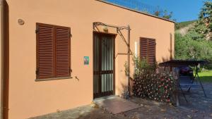 a house with a door and a table and flowers at Il Nibbio in Vecchiano